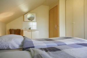 a bedroom with a blue and white bed and a kitchen at Val du Roannay in Stavelot