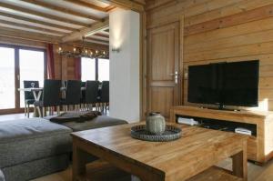 a living room with a couch and a television at Val du Roannay in Stavelot