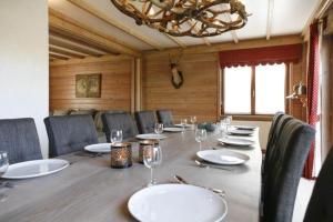 a dining room with a table and chairs and a chandelier at Val du Roannay in Stavelot