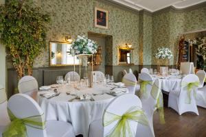 a banquet room with white tables and white chairs at Thomas Paine Hotel in Thetford