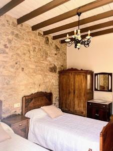 a bedroom with two beds and a stone wall at Casa Rua in Lira
