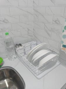 a kitchen counter with a sink and a basket with dishes at Tiny House Anjung Batu Tangkak in Tangkak +12 photos