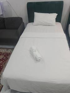 a white shoe sitting on top of a bed at Tiny House Anjung Batu Tangkak in Tangkak