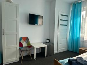 a bedroom with a desk and a chair and a tv at Na Kwiatkowskiego in Sandomierz