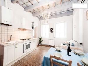 a white kitchen with a table and a couch at Happy Florence Santa Croce 1 in Florence