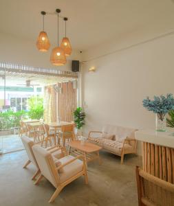 a living room with tables and chairs and a couch at Hi Sea Hostel - Boutique Style in Center, 15 min Walk from Pier in Thong Sala