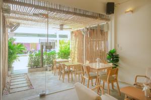 a restaurant with tables and chairs and a large window at Hi Sea Hostel - Boutique Style in Center, 15 min Walk from Pier in Thong Sala