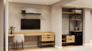a home office with a desk and a tv on a wall at Hotel Campo Largo Comfort in Campo Largo