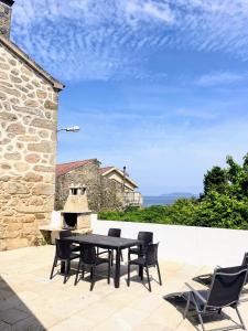 a patio with a table and chairs and a fireplace at Casa Rua in Lira