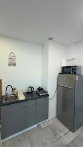 a small kitchen with a sink and a refrigerator at Na Kwiatkowskiego in Sandomierz