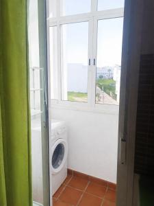 a laundry room with a washing machine and a window at Casa Nankurunaisa in Vejer de la Frontera