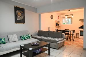 a living room with a couch and a table at West of Preveza Luxury Jacuzzi Apartment in Preveza
