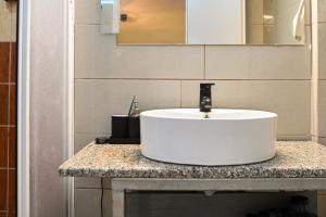 a bathroom with a white sink and a mirror at West of Preveza Luxury Jacuzzi Apartment in Preveza