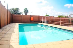 a swimming pool on a building with a fence at Divine Guest Lodge in Rustenburg