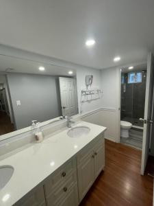 a bathroom with two sinks and a large mirror at Arkona Home in Toronto +1 photo