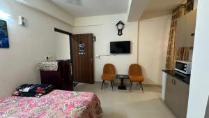 a bedroom with a bed and a desk and a tv at THE NEST - Kingdom in Ghaziabad