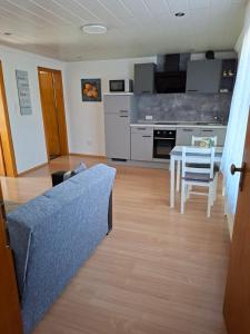 a living room with a couch and a table and a kitchen at Dirks Apartment mit Weitblick in Mammelzen
