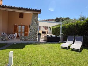 a patio with two chairs and a couch in a yard at Villa Anna in Costa Rei