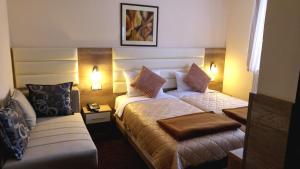 ein Hotelzimmer mit zwei Betten und einer Couch in der Unterkunft Hotel Čile in Kolašin