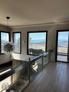 a living room with a table and some windows at VILLA KTIMA MELINA Pelio ΒΙΛΑ ΜΕ ΠΙΣΙΝΑ ΒΟΛΟΣ ΠΗΛΙΟ in Álli Meriá