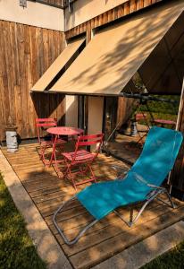 three chairs and a table on a deck at Le Cercle de Victoria stationnement privé petit déjeuner compris in Bourges