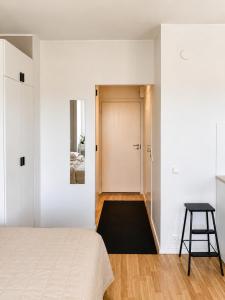 a bedroom with a bed and a stool next to a door at Gallen-Kallelankatu 9 in Pori +4 photos