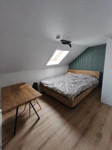 a bedroom with a bed and a table in it at Willa Sunny Garden in Sint-Laureins