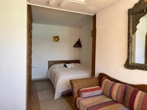 a bedroom with a bed and a mirror and a couch at Bright Riad with Panoramic Views - Oudayas in Rabat