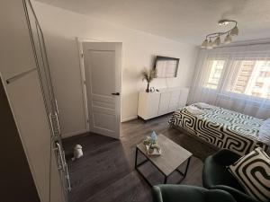 a bedroom with a bed and a living room with a table at Ventos g 51 Apartment in Mažeikiai
