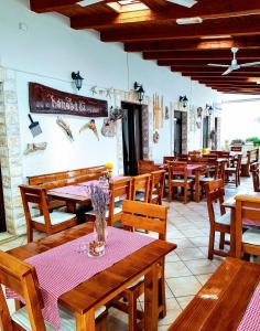 a restaurant with wooden tables and wooden chairs at Villa Palčić in Novalja