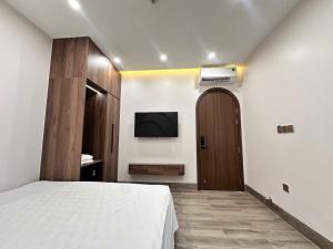 a bedroom with a bed and a tv on a wall at Hidden Green Hotel Tam Coc in Vũ Lâm