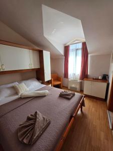a bedroom with a large bed with towels on it at Villa Palčić in Novalja