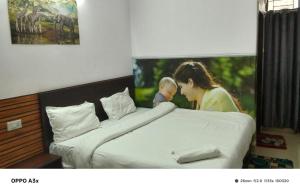 a woman holding a baby on top of a bed at hotel tamanna in Lucknow