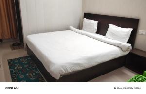 a bed in a hotel room with white sheets and pillows at hotel tamanna in Lucknow