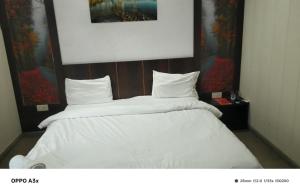 a bedroom with two beds with white sheets at hotel tamanna in Lucknow +3 photos
