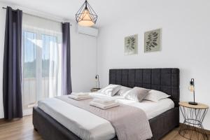 a bedroom with a large bed and a window at Maslina in Vrsi +24 photos