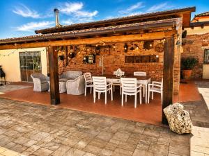 a patio with a table and chairs and a brick wall at Il Casale di Lucullo-Holiday Home with Pool and Spa- in Lucignano