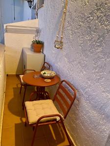 a small table and chairs sitting next to a wall at Studio DKMK in Malia