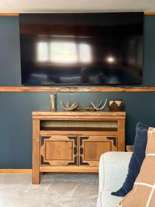 a wooden entertainment center with a large flat screen tv at The Remington House in Woodruff