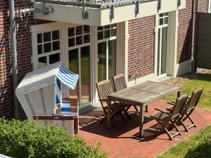 a wooden table and chairs on a patio at Traumwooge - Traumferien mit Luxus in Wangerooge