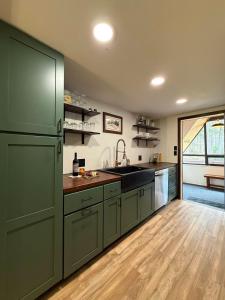 a kitchen with green cabinets and a large refrigerator at The Remington House in Woodruff
