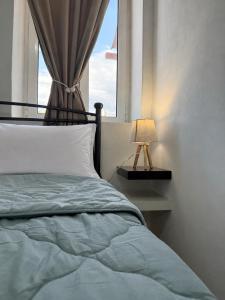a bedroom with a bed with a window and a lamp at Above the Sea - Sparto in Spartos
