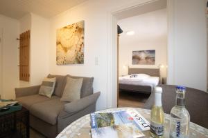 a living room with a couch and a bed at Haus Roseneck App.2 in Hörnum