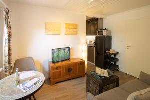 a living room with a tv and a table at Haus Roseneck App.2 in Hörnum