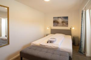 a small bedroom with a bed and a mirror at Haus Roseneck App.2 in Hörnum