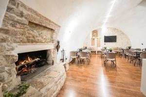 a room with a fireplace and tables and chairs at Hotel Paradise Rooms in Bitritto
