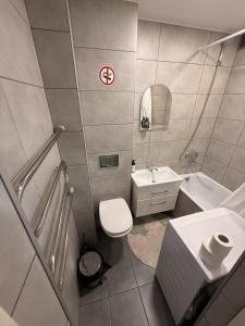a bathroom with a white toilet and a sink at Ventos g 51 Apartment in Mažeikiai