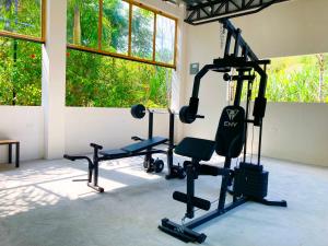 a gym with several tread machines in a room with windows at Hotel La Costa Internacional in Puerto López