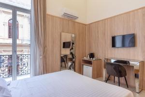 a hotel room with a bed and a television at Kore Luxury Suite e Spa in Naples