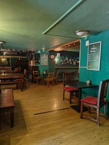 a restaurant with wooden tables and chairs and a menu at Hotel Freihof in Glarus